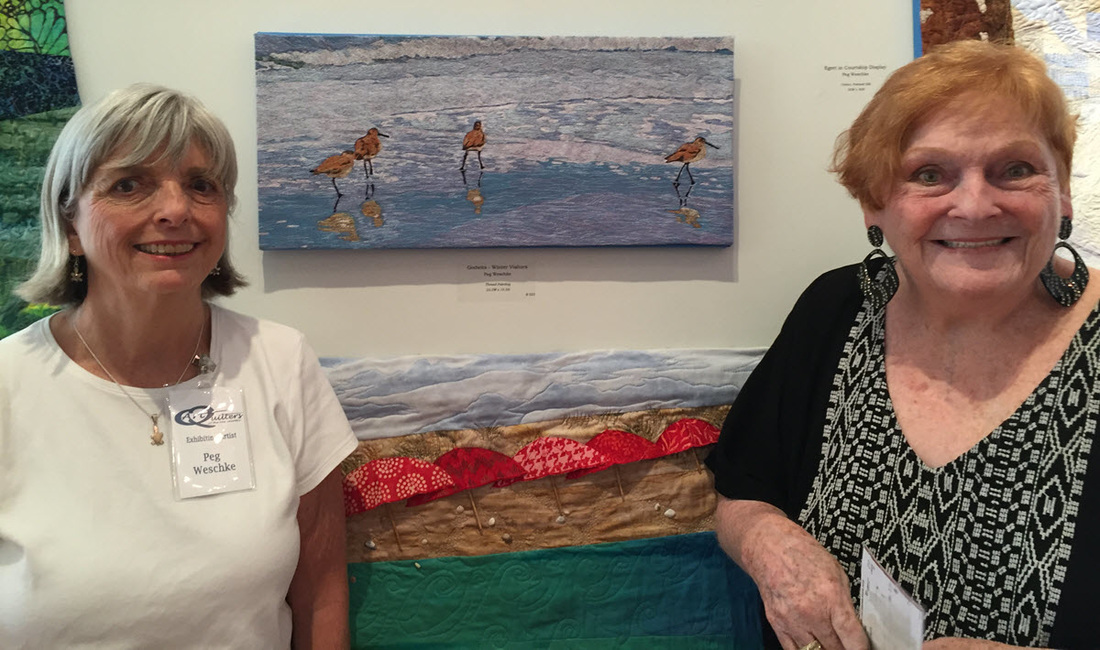 Peg Wesehke posing with purchaser of her art quilt entitled Godwits Thread Painting